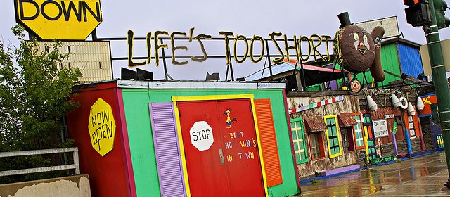 Multicolored beach shop with sign: "Slow Down. Life's Too Short"